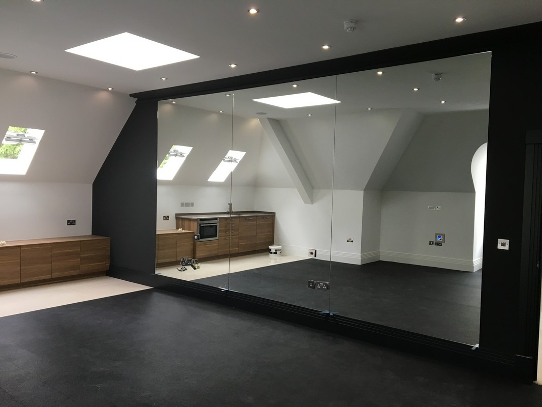 Frameless glass wall dividing loft conversion in Lower Edmonton