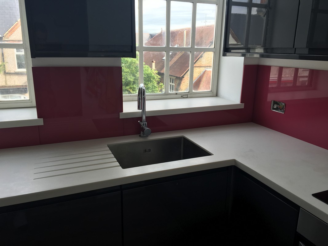 Deep plum coloured glass splashback in modern Lower Edmonton kitchen
